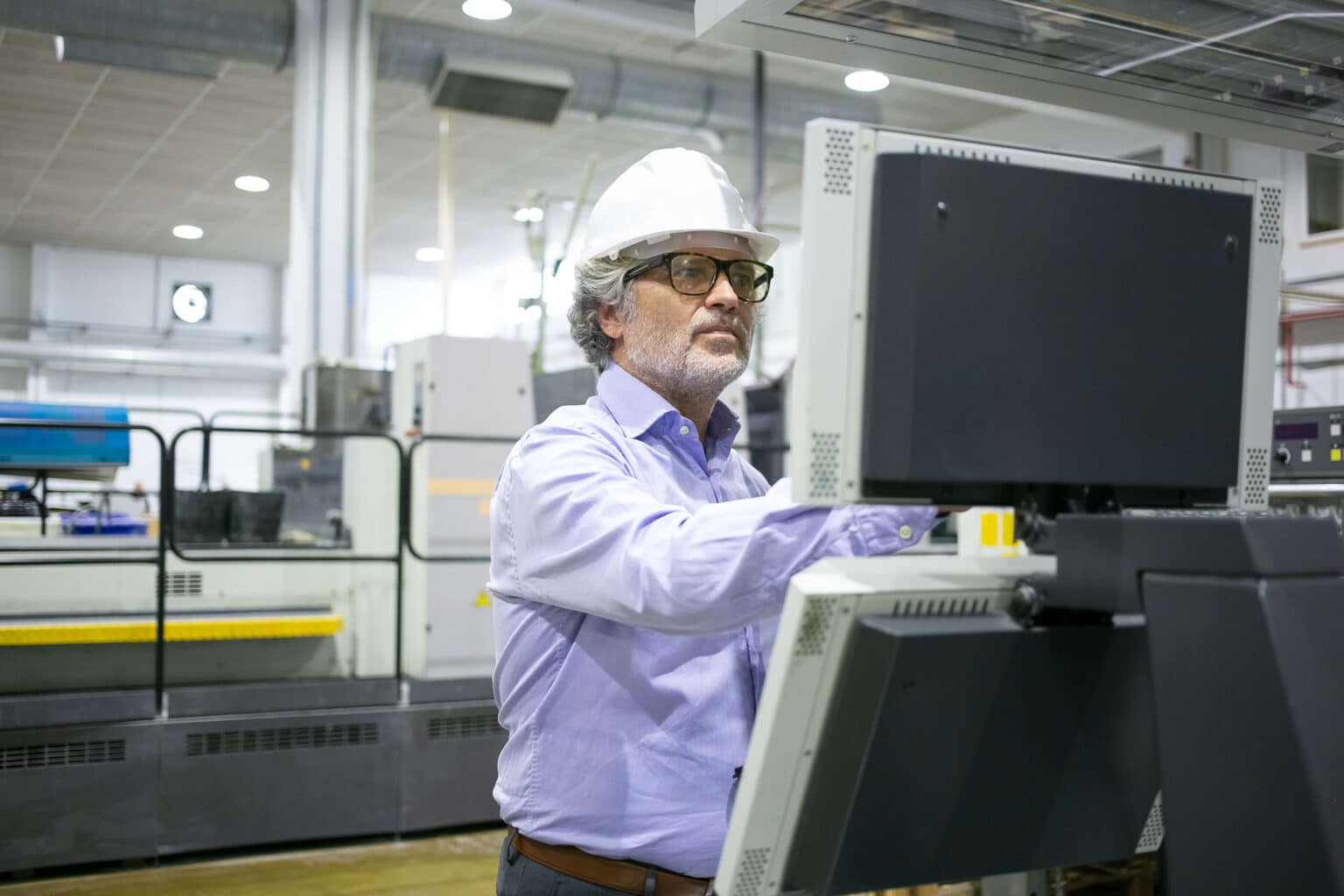 serious-male-plant-manager-hardhat-glasses-operating-industrial-machine-pushing-buttons-control-panel (1)